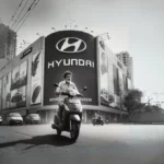 A man rides a scooter past a Hyundai automobile showroom in Mumbai, India