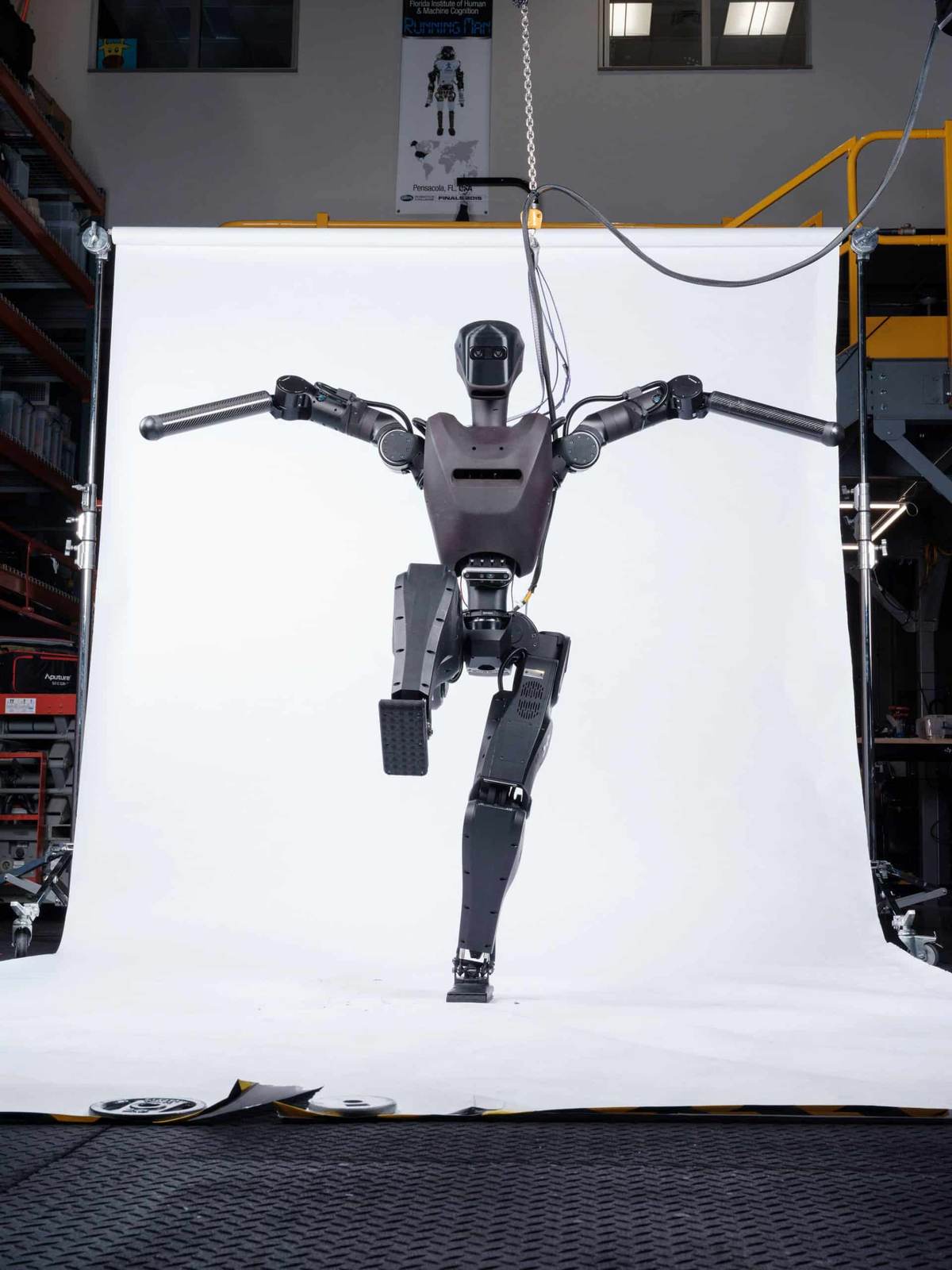 Full body view of the IHMC Alex humanoid robot hanging from a test rig in the lab