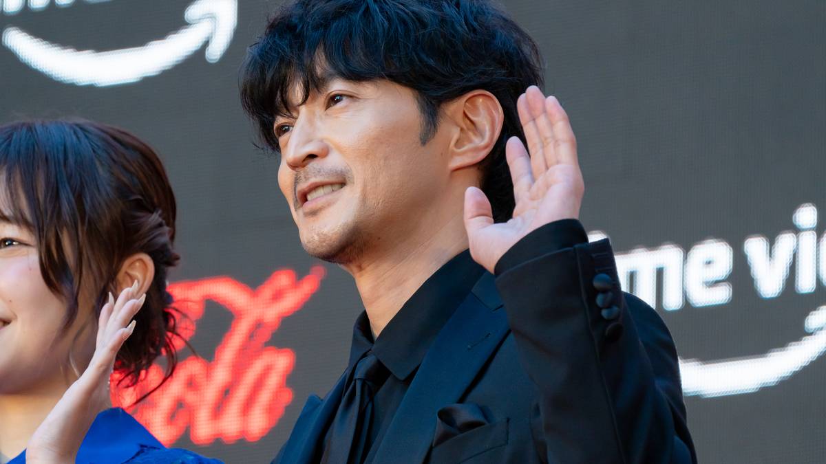 Anime voice actor Kenjiro Tsuda waving at a red carpet event