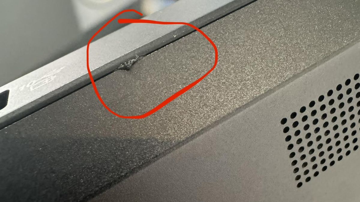 Scrape damage on the corner edge of the Lenovo Legion 7i laptop highlighted in red