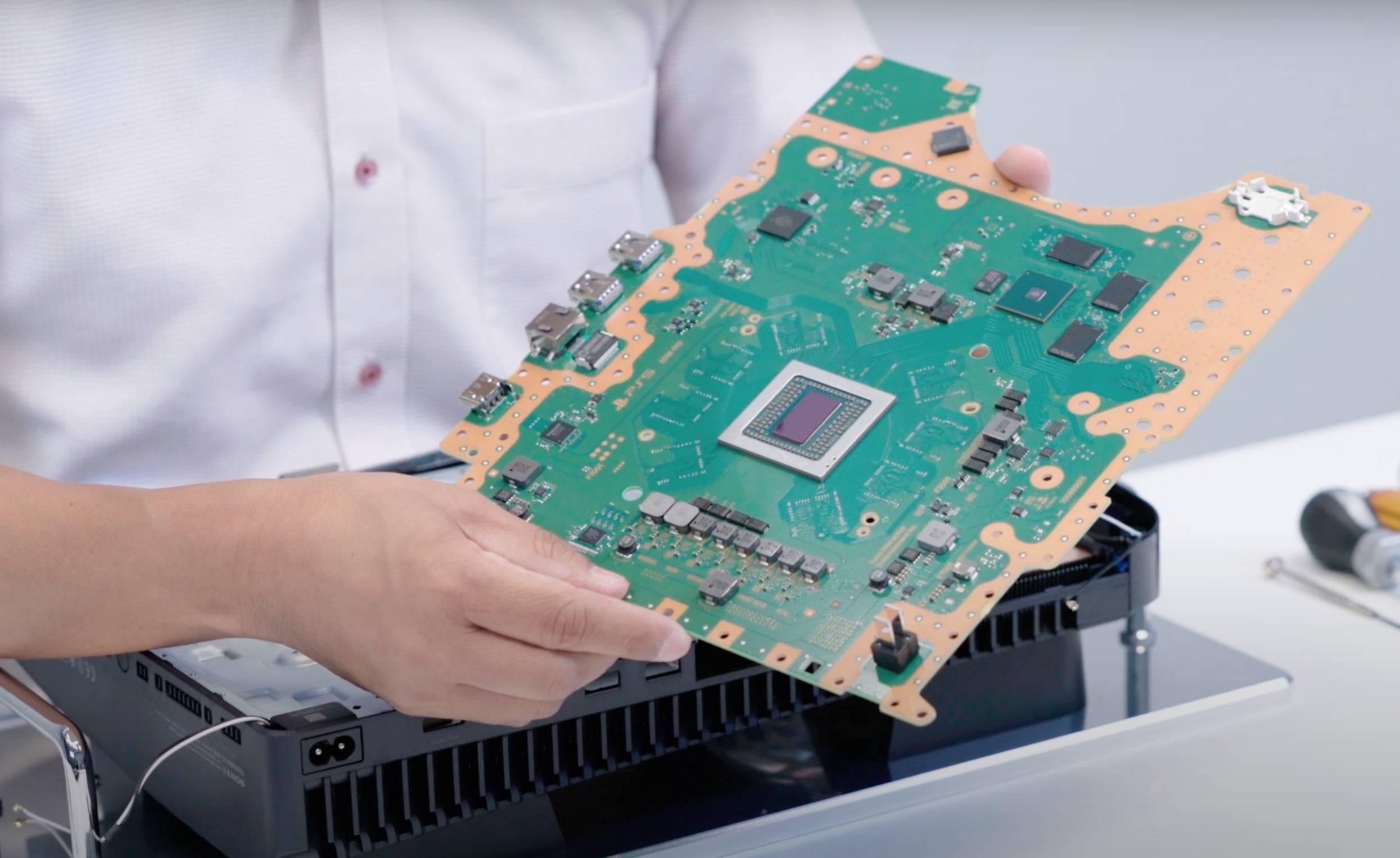 Sony engineer holding a PlayStation 5 motherboard during an official teardown video